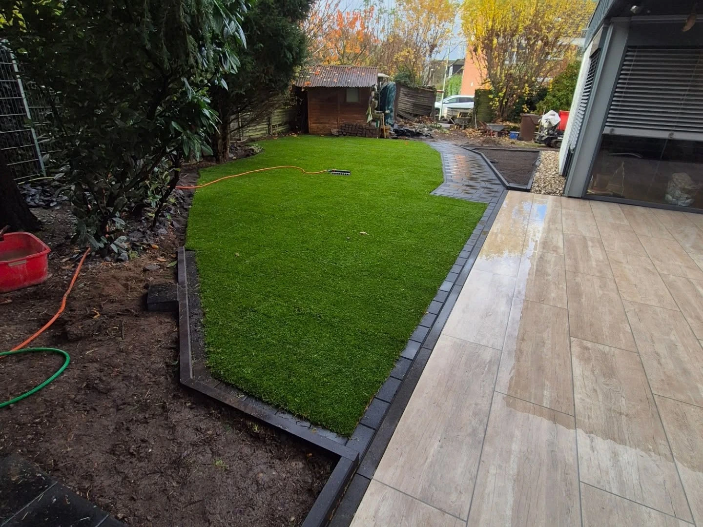 Neu angelegter Garten mit Rasenfläche, Beeten und gepflasterter Terrasse in Viersen