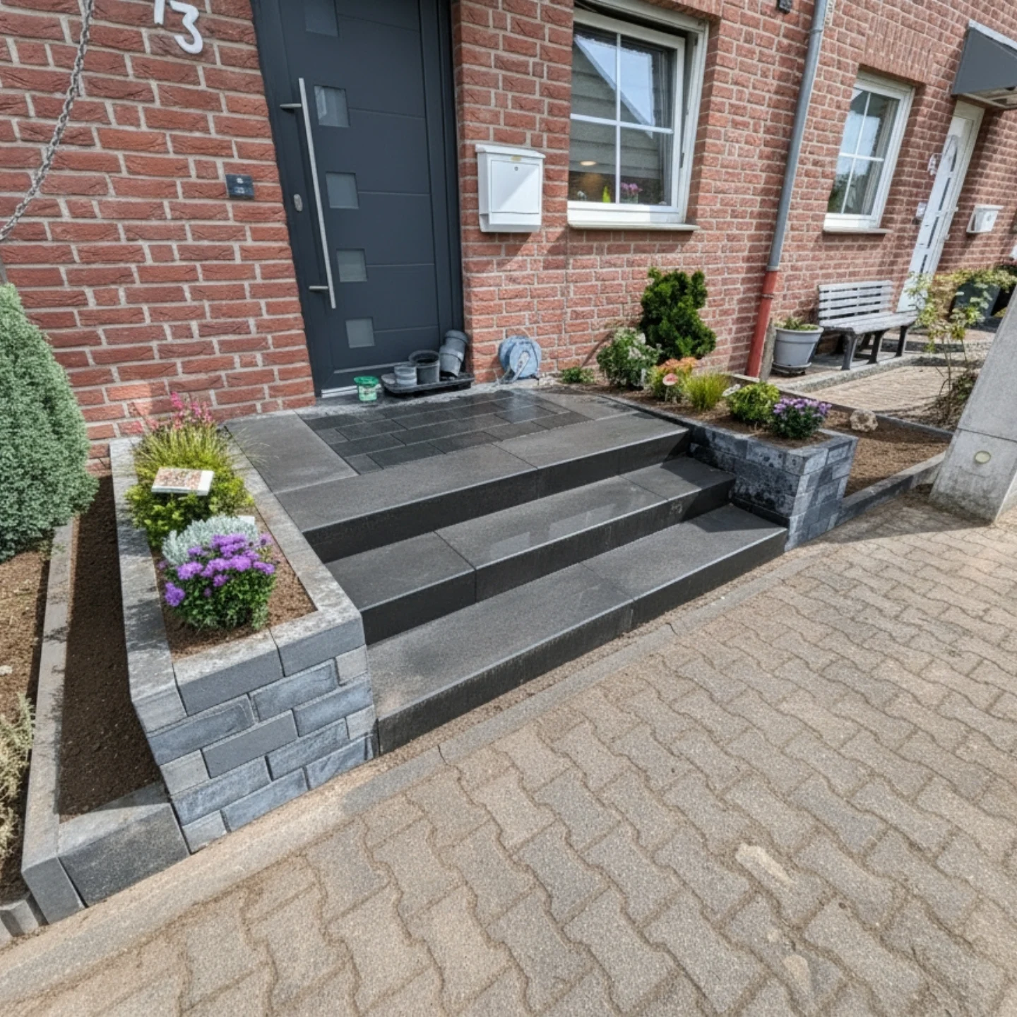 Moderne Gartengestaltung mit Rasen, Beeteinfassung und Sitzbereich