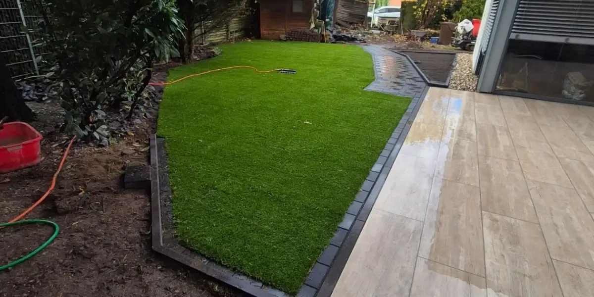 Neu angelegter Garten mit Rasenfläche, Beeten und gepflasterter Terrasse in Viersen
