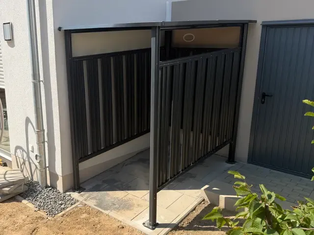 Anthrazitfarbener Fahrradunterstand aus Metall an einer Hauswand in Viersen-Dülken, auf gepflasterter Fläche montiert