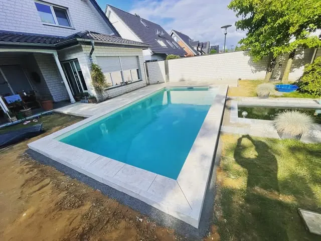Rechteckiger Pool mit neu verlegter heller Randsteineinfassung