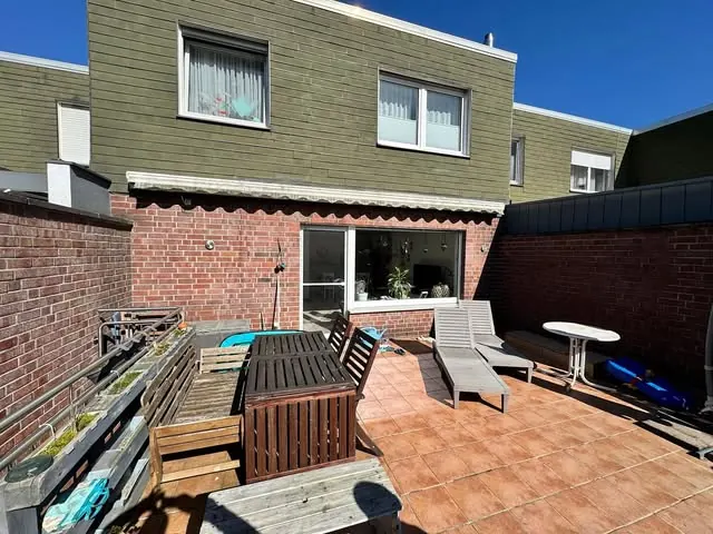 Terrasse vor der Sanierung mit alten terrakottafarbenen Fliesen und ausgeblichener Markise