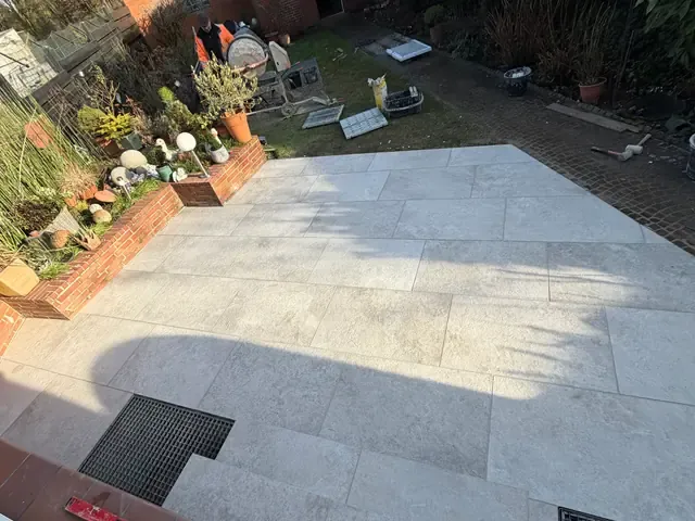 Verlegung heller Großformatplatten auf einer Terrasse in Viersen-Dülken, passgenau um zwei Lichtschächte geschnitten